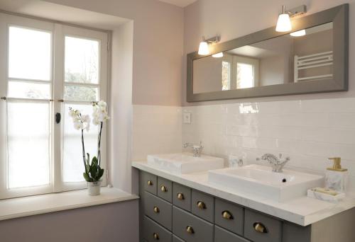 a bathroom with two sinks and a mirror at Domaine du Plessis in Le Plessis-Luzarches