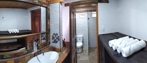 a bathroom with a sink and a toilet and a mirror at Cabañas & Glamping De Ruana Por Boyacá in Paipa