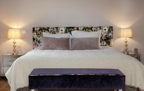 a bedroom with a large bed with two lamps at Domaine du Plessis in Le Plessis-Luzarches