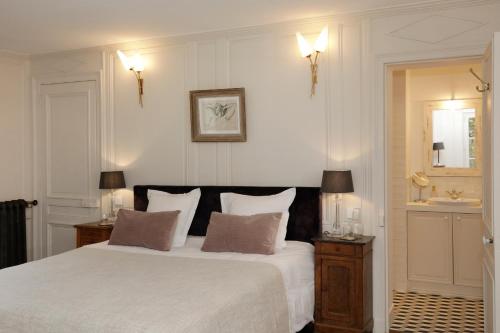 a bedroom with a large white bed and a sink at Domaine du Plessis in Le Plessis-Luzarches