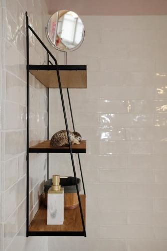a black shelf in a bathroom with a mirror at Domaine du Plessis in Le Plessis-Luzarches