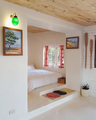 a bedroom with a bed and a window at Maliblues Bed & Art Gallery in Chumphon