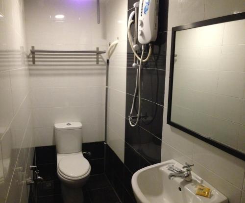 uma casa de banho com um WC, um lavatório e um telefone em Pengkalan Dua em Malaca
