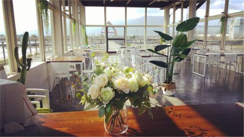 un vase rempli de fleurs blanches sur une table en bois dans l'établissement Sky Island B&B, à Jiaoxi