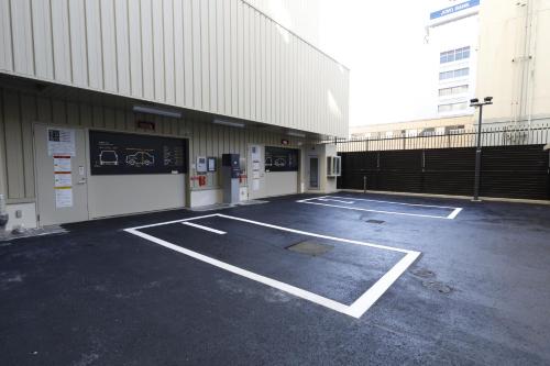 an empty parking lot in front of a building at Dormy Inn Mito in Mito