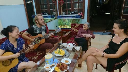 a group of people sitting in a living room playing guitar at Halo Bay Homestay in Ha Long