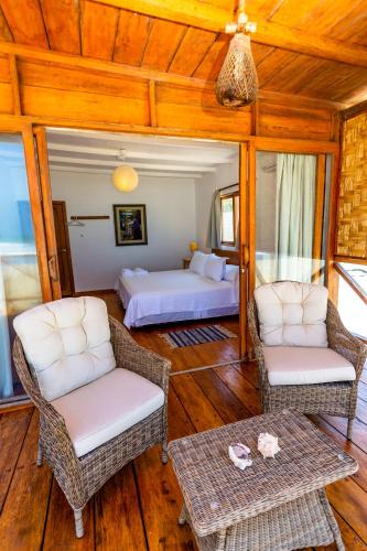 a room with two beds and two chairs and a table at Hotel Punta Camarón Bungalows & Suites in Zorritos