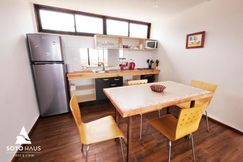 a kitchen with a table and chairs and a refrigerator at SOTO HAUS Totoralillo Tierra in Coquimbo