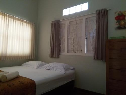 a bedroom with a large bed with a window at Omah Ngadiwinatan Syariah in Yogyakarta