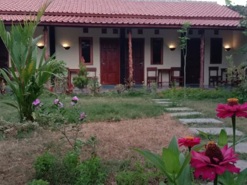 een huis met een tuin en bloemen ervoor bij Sunrise Banyuwangi Homestay in Banyuwangi