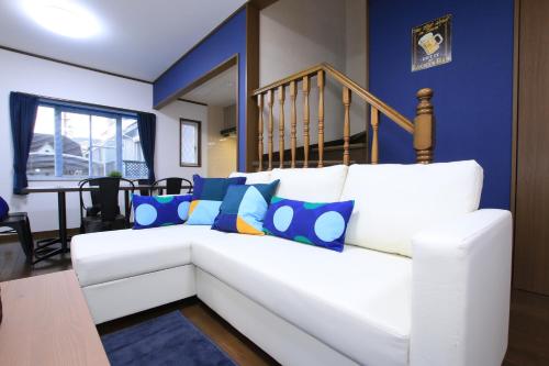a white couch with blue pillows in a living room at Tiz wan 津名あわじ in Awaji