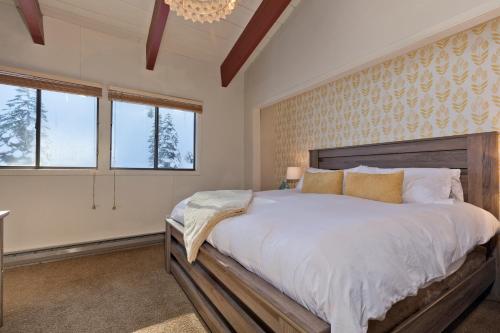 een slaapkamer met een groot bed en 2 ramen bij Blue Jay Chalet in Mammoth Lakes