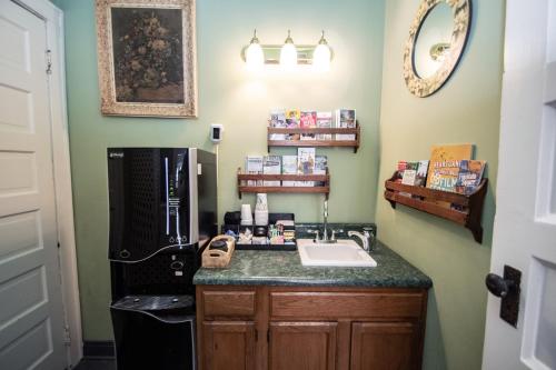 a kitchen with a sink and a black refrigerator at Looking Glass Inn in Indianapolis