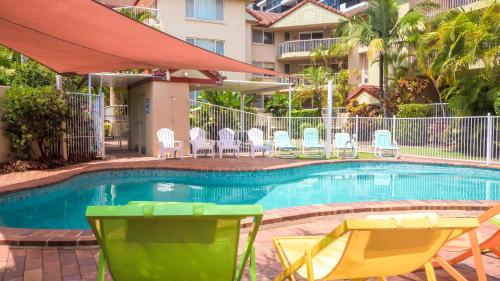 a swimming pool at a hotel with chairs and tables at Jubilee Views Holiday Apartments in Gold Coast