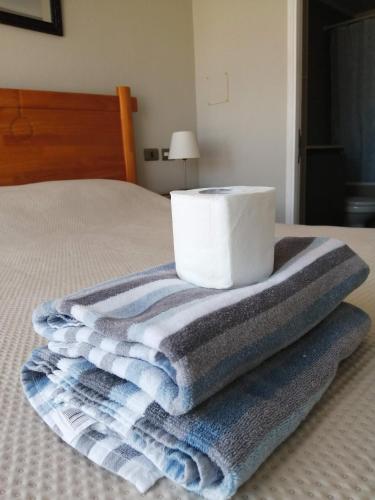 a pile of towels sitting on top of a bed at 2 Torres Calama in Calama
