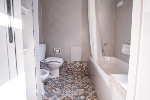 a bathroom with a toilet and a tub and a sink at El Rolito in Sierra de la Ventana