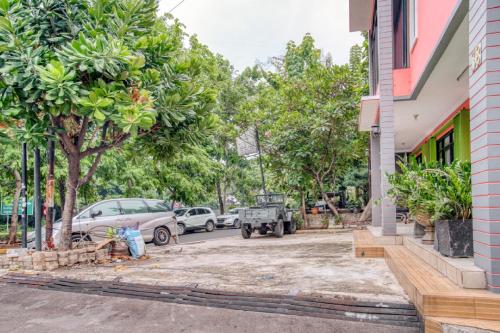 a street in front of a building with trees at RedDoorz near Taman Mini Jakarta in Jakarta