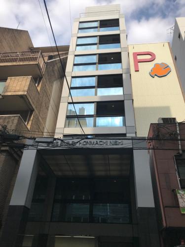 un bâtiment avec un logo p sur celui-ci dans l'établissement WELLSTAY Honmachi, à Osaka