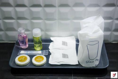 a tray with two eggs and a bagel and a bottle ofologne at The Harbour Front Hotel in Suratthani