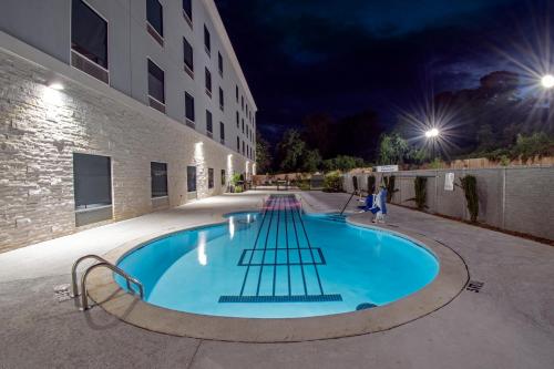 a swimming pool outside of a building at night at Holiday Inn Express & Suites Memphis Arpt Elvis Presley Blv by IHG in Memphis