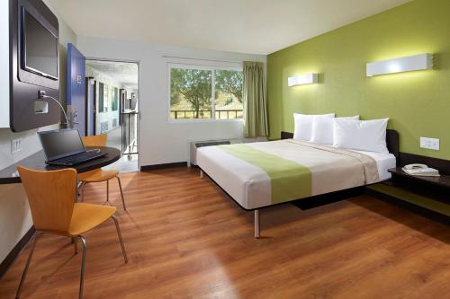 um quarto de hotel com uma cama e um computador portátil numa secretária em Motel 6-Redlands, CA em Redlands