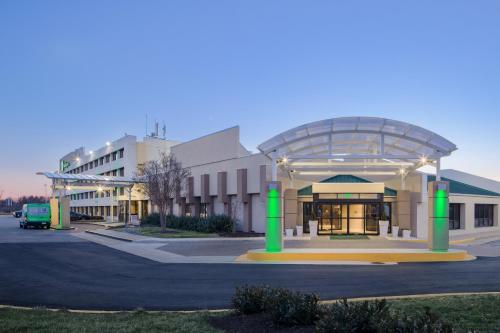a large building with a glass canopy in a parking lot at Holiday Inn Washington-College Pk I-95 in College Park