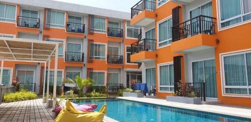 een appartementencomplex met een zwembad ervoor bij Long N Joy Samui in Chaweng Beach