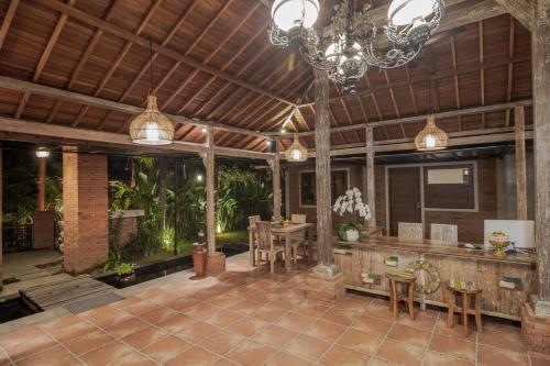 a large patio with a dining area with a chandelier at Bubu Suite by Prasi in Ubud