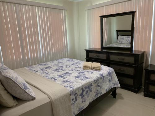 una camera da letto con un letto con un comò e uno specchio di Casa De Pedro Entire Apartment a Mangilao
