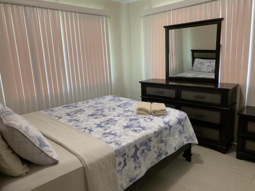 a bedroom with a bed with a dresser and a mirror at Casa De Pedro Entire Apartment in Mangilao