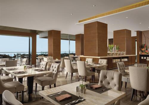 a restaurant with wooden tables and chairs and tablesearcher at InterContinental Bandung Dago Pakar by IHG in Bandung