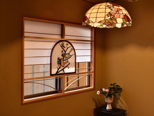 a stained glass window with a bird on a branch at Hotel Hagoromo in Shizuoka