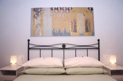 a bedroom with a bed with two lamps and a painting at B&B Cal Torello in Urbino