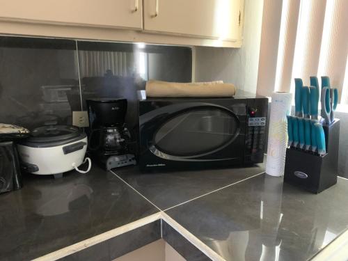 a microwave oven sitting on a counter in a kitchen at Casa De Pedro- Entire Villa in Mangilao