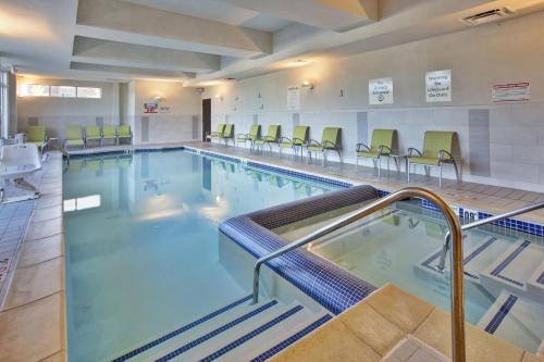 a large swimming pool with chairs in a building at Holiday Inn Detroit Metro Airport, an IHG Hotel in Romulus