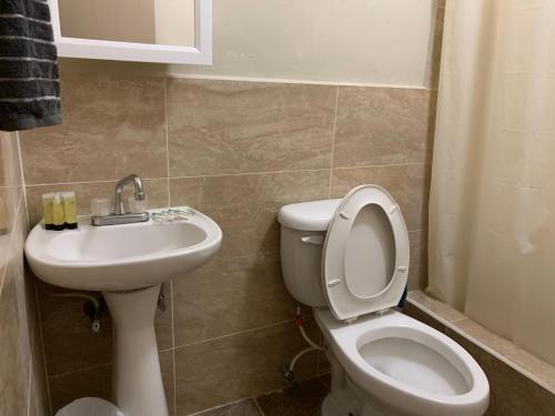 a bathroom with a toilet and a sink at Entire Private Villa- Casa De Pedro in Mangilao