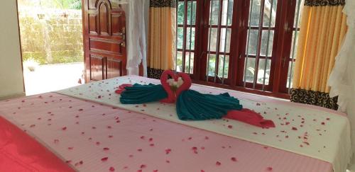a cake with red and green decorations on top of a bed at Pradeep Guest House in Mirissa