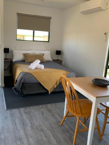 a bedroom with a bed and a table and a table sidx sidx at Swansea Holiday Park Tasmania in Swansea