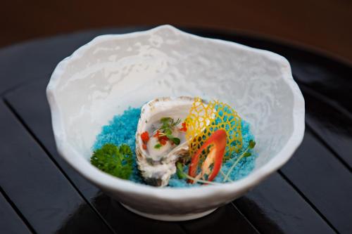 a white bowl with food in it on a table at Scarlet Pearl Cruises - Wonder On Lan Ha Bay in Ha Long