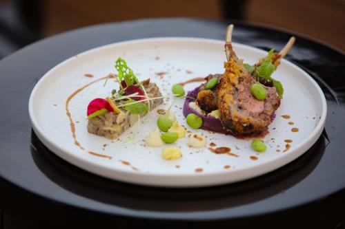 a white plate with food on a table at Scarlet Pearl Cruises - Wonder On Lan Ha Bay in Ha Long