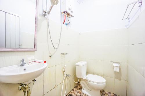 uma casa de banho com um lavatório, um WC e um chuveiro em OYO 1720 A2b Residence em Malalayang