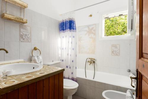 a bathroom with a sink and a toilet and a tub at Katoussa in Paleokastritsa