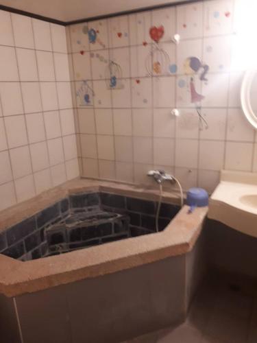 a bathroom with a sink and a bath tub with at Chihpen Hot Spring Hotel in Wenquan