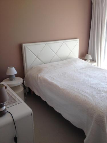 une chambre avec un lit blanc et une fenêtre dans l'établissement Quartier piscine municipale Bel Appart 4 pers terrasse parking wi-fi, à Vence