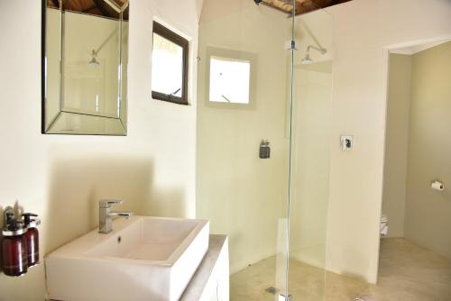 a white bathroom with a sink and a shower at Bayala Private Safari Lodges in Hluhluwe