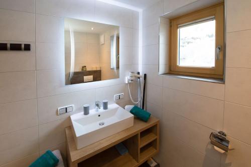 a bathroom with a sink and a mirror at Appartement Neumayer in Viehhofen