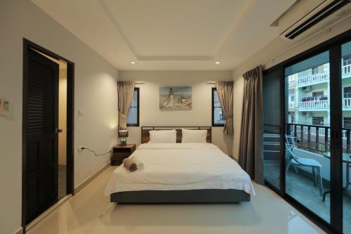 a hotel room with a bed and a window at Nalanta Hotel Pattaya in Pattaya Central