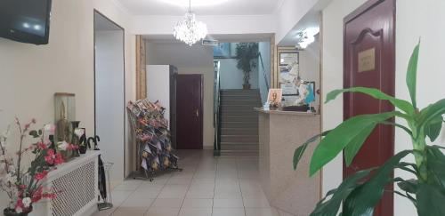 a hallway with a staircase in a house with a plant at Altyn-Adam Hotel in Astana