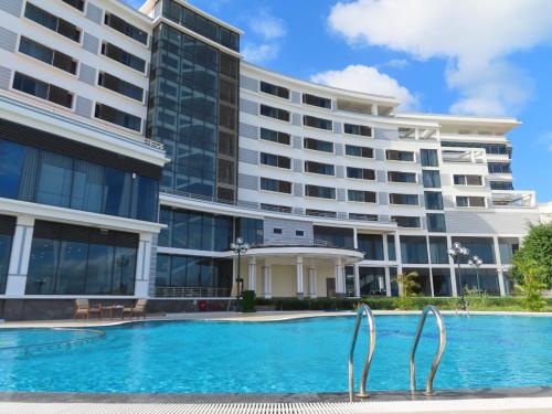 un hôtel avec une piscine en face d'un bâtiment dans l'établissement Navy Hotel Cam Ranh, à Cam Ranh