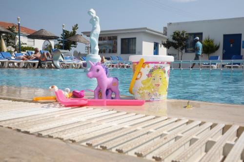 a pool with a toy horse and a child on a raft at Mavi Pansiyon & Restaurant in Didim